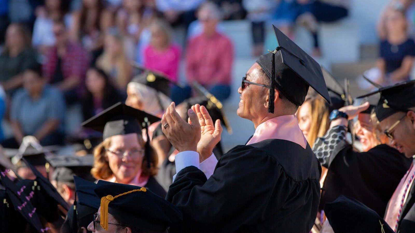 Male graduate student applauding during commencement