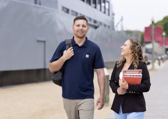 Students walking at Liberty Station campus in front of USS Recruit Boat
