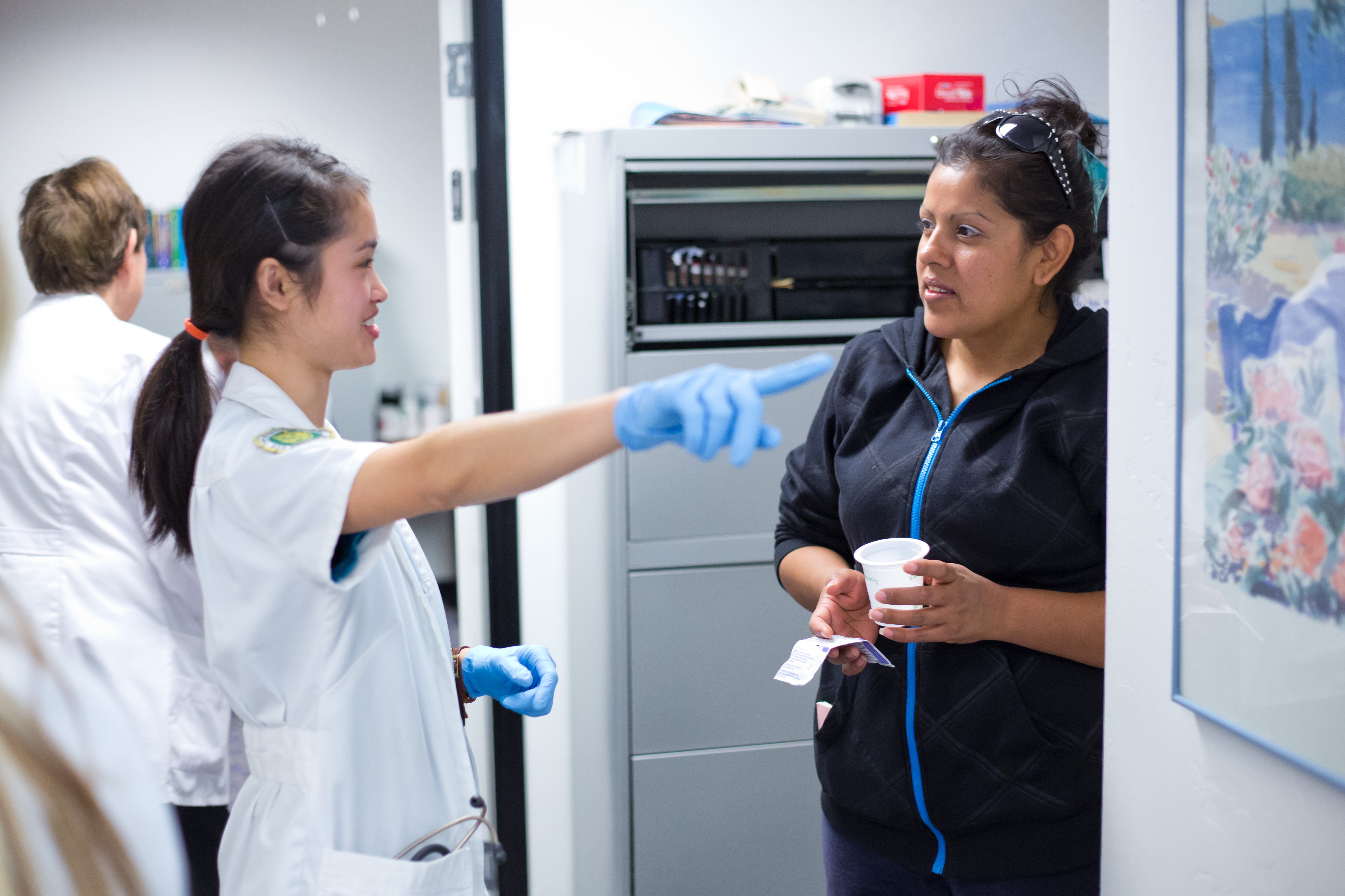 HPC nurse points and directs a patient to a room