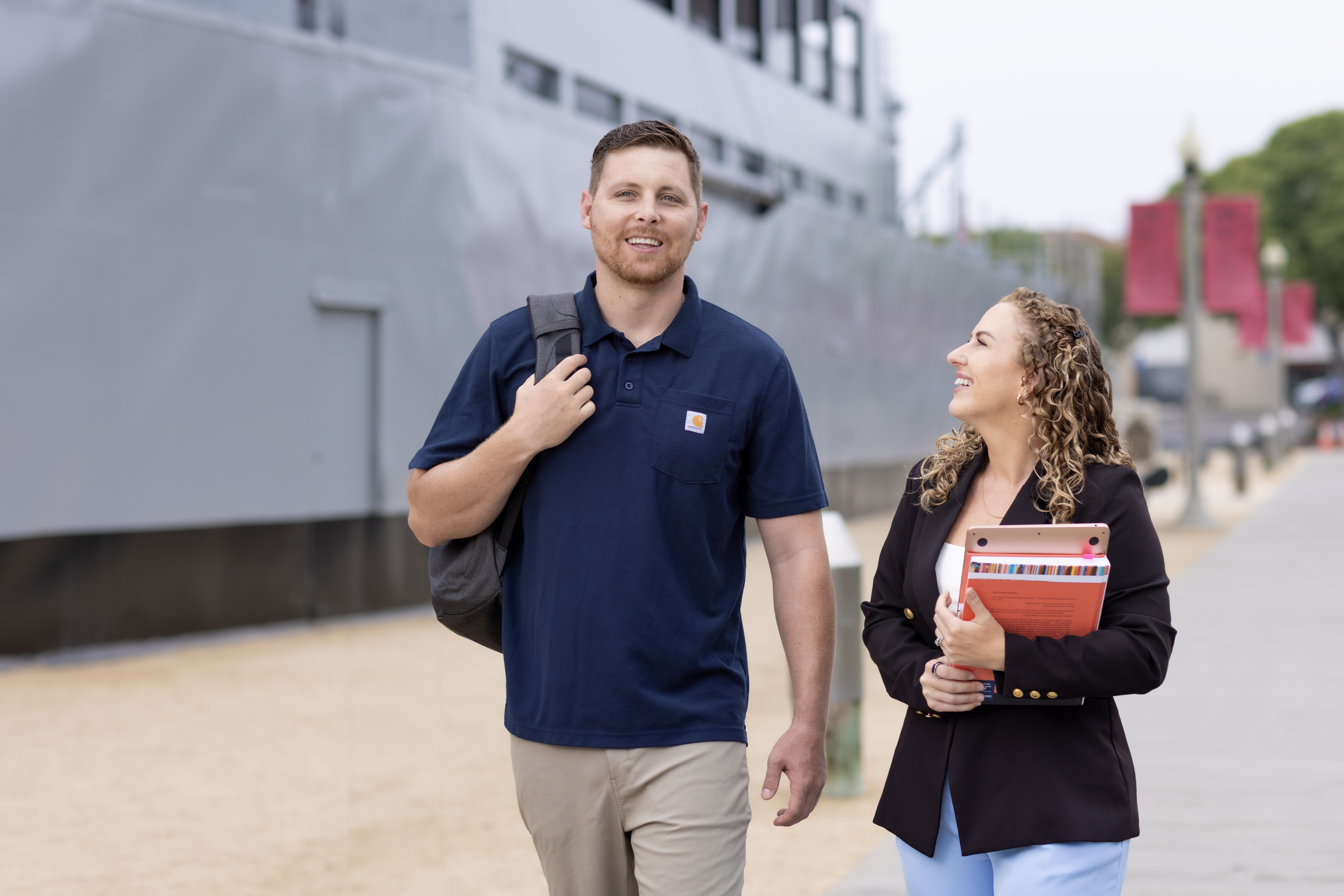 Students walking at Liberty Station campus in front of USS Recruit Boat