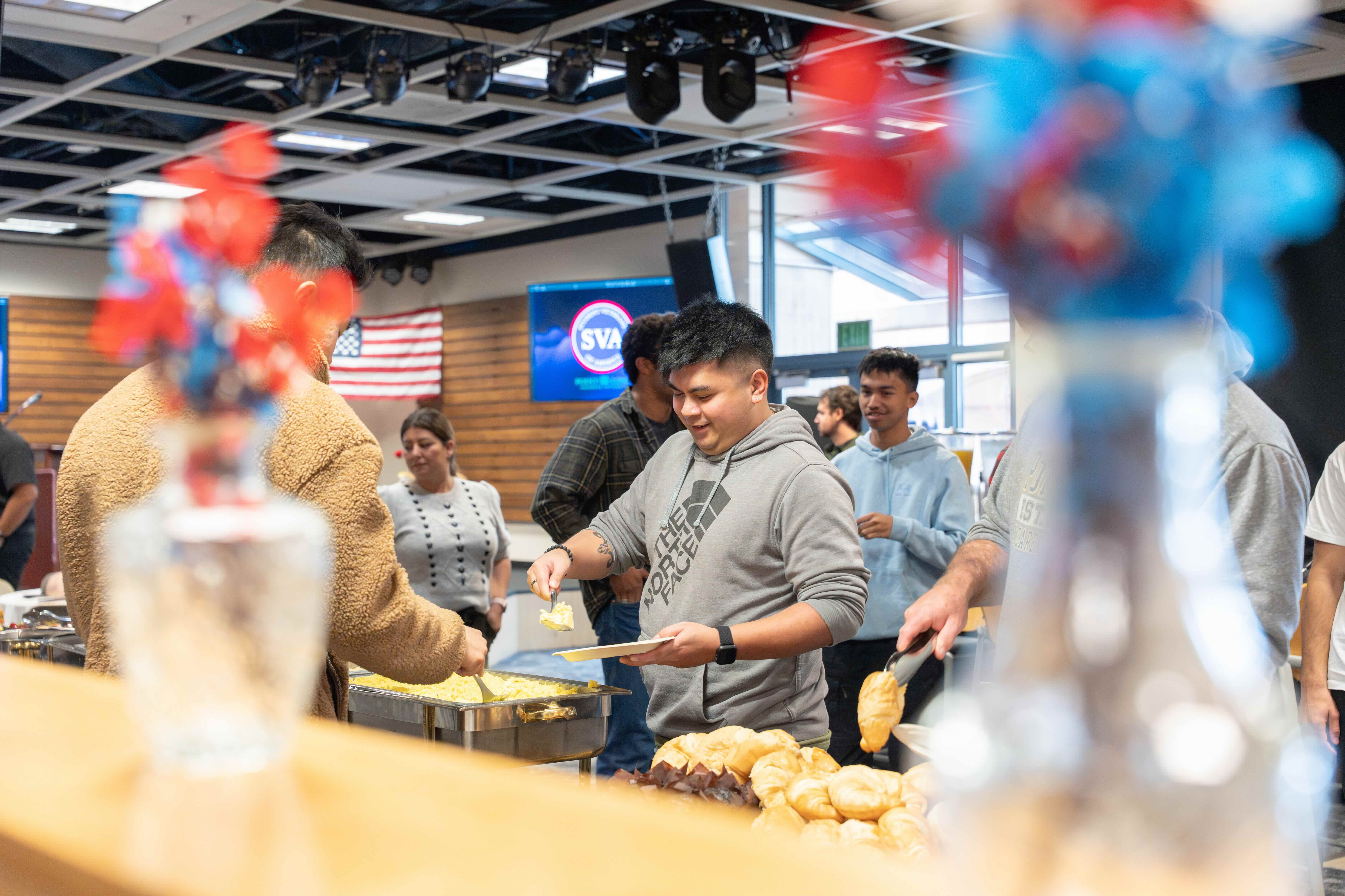SVA member at the buffet table filling up plate at the 2026 Warrior's Breakfast.