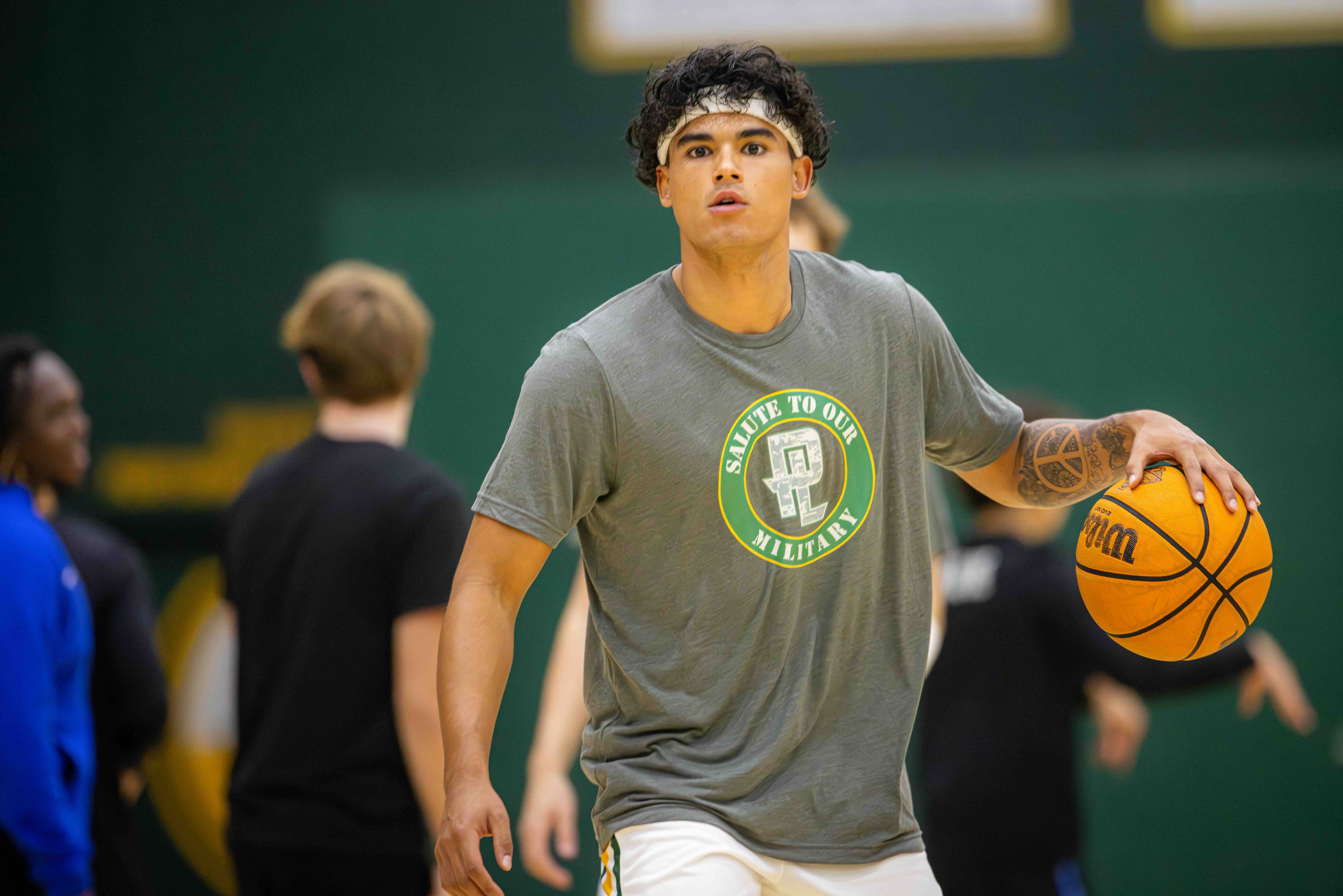 Male PLNU basketball student mid-move before official game in warm-ups.