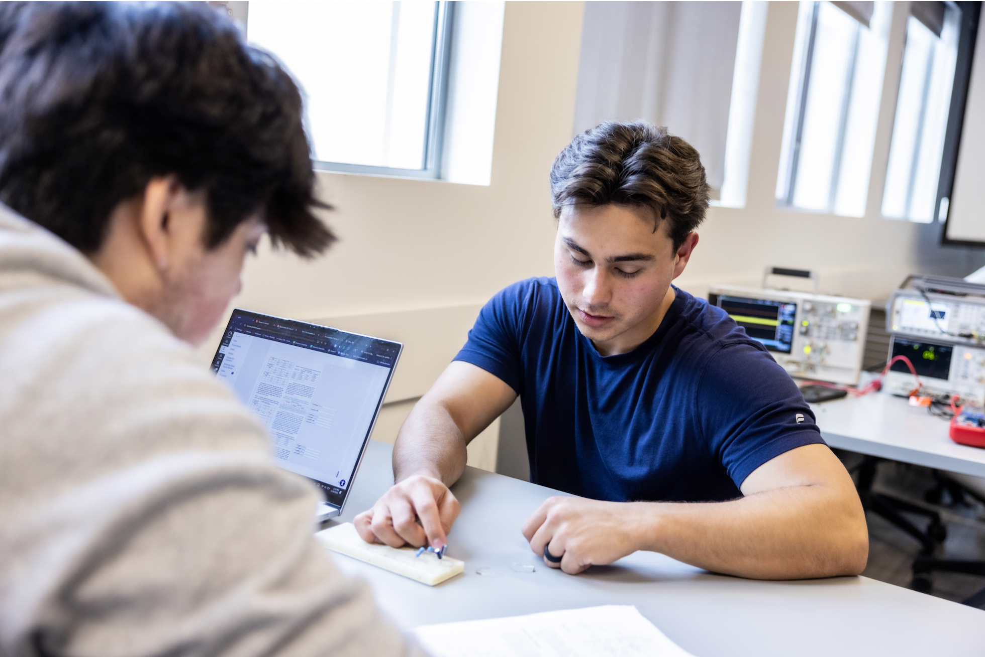 PLNU students working together on a technical project in the engineering lab.