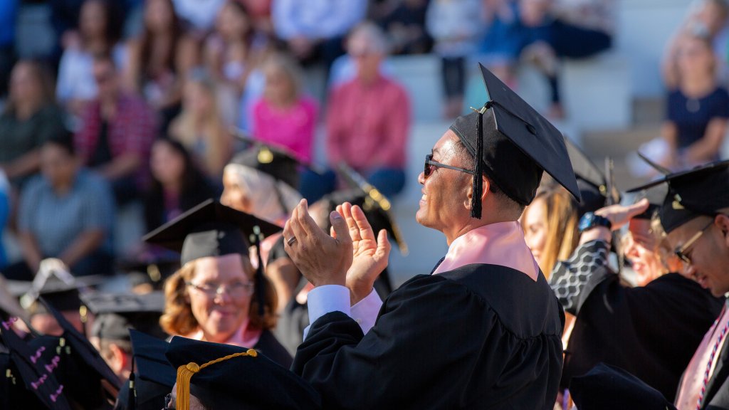 Male graduate student applauding during commencement