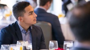 A professionally dressed student attends a business networking event.