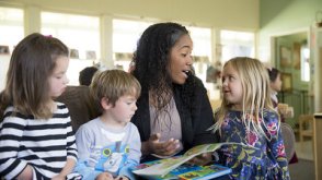 Student reading with children 