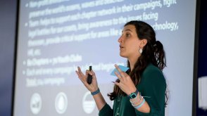 teacher talking in front of a power point slide