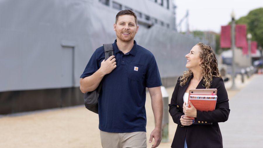 Students walking at Liberty Station campus in front of USS Recruit Boat