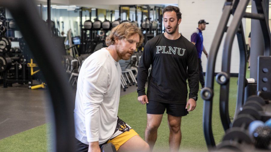PLNU health coach observes a SD Seals player lifting weights