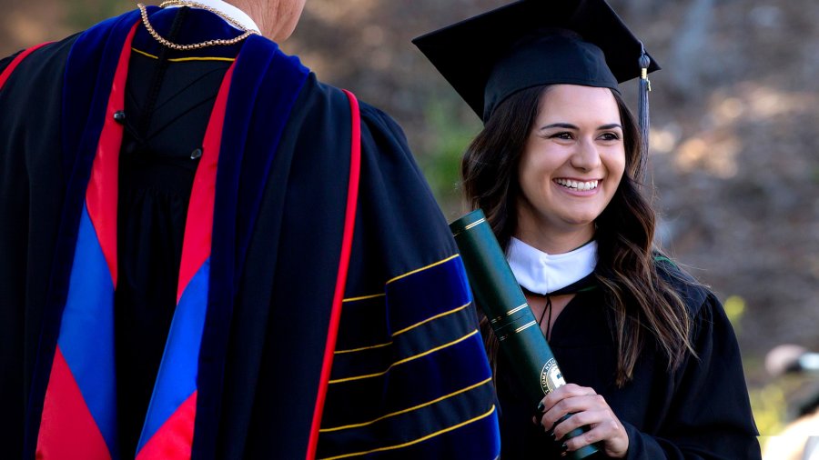 Female student receives her diploma from President Bob Brower