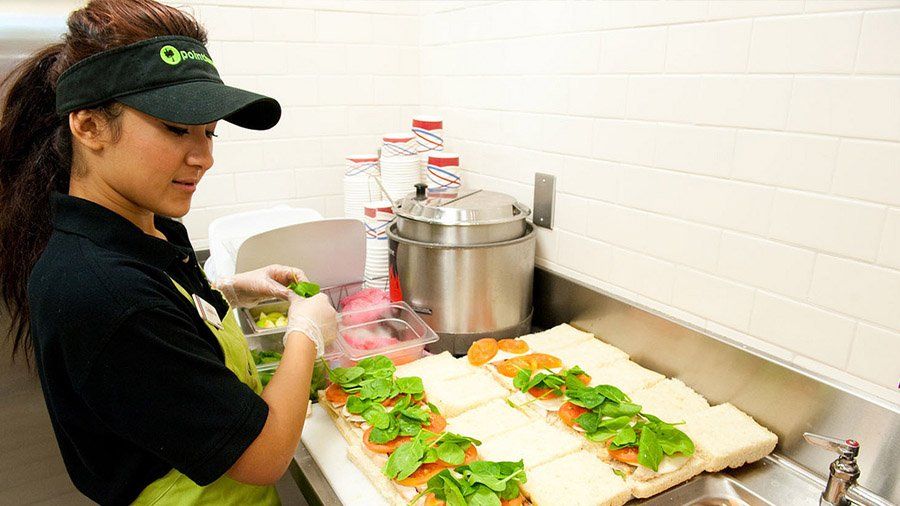 A student worker prepares eight sandwiches for hungry customers. 
