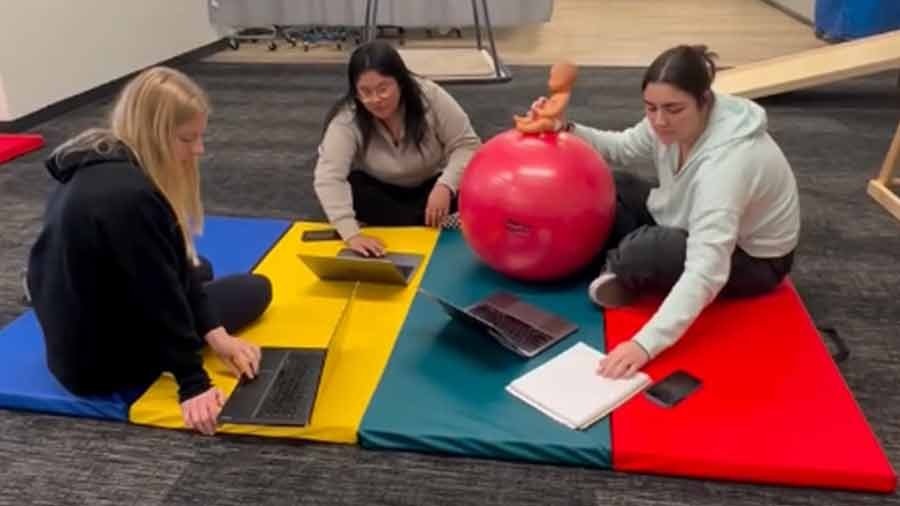 Three MSOT students work on a project involving childcare