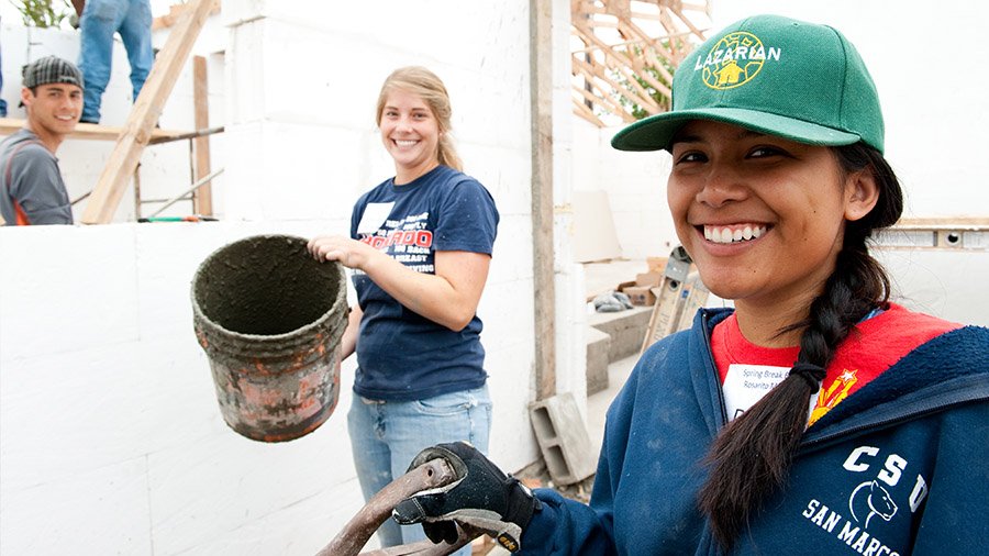 A group of PLNU students pause to smile at the camera as they work on a construction project in Mexico.