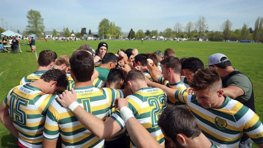 PLNU Rugby Club players gather in a huddle to pray before a match.