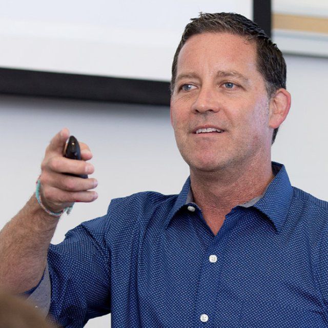 Randal Schober teaching class with a powerpoint clicker in his hand