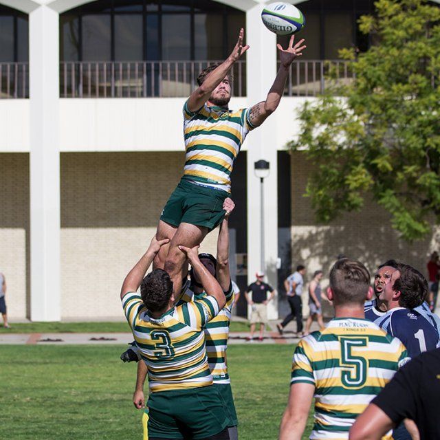 A PLNU Rugby Club athlete is lifted up by his teammates in order to catch the flying ball.