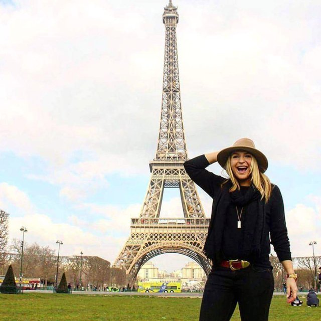 A student stands in front of the Eiffel Tower in Paris