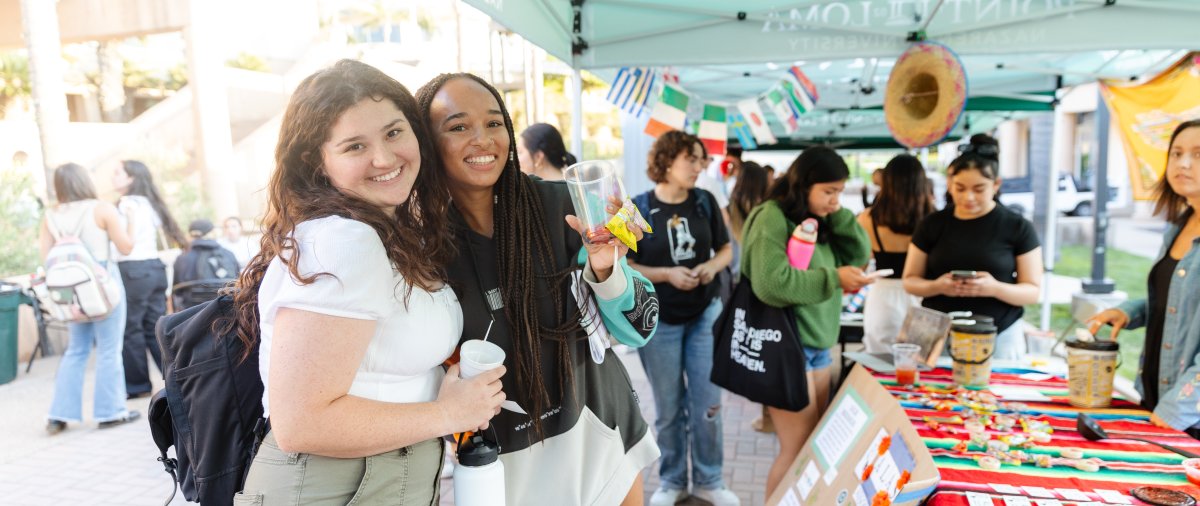 two students together at multicultural fair on campus