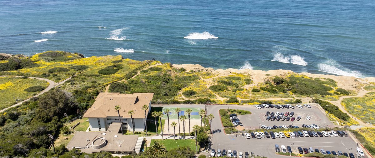 Campus housing on the beach with basketball court and parking lot