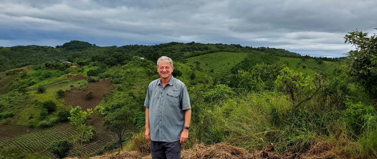 Scott Sabin stands on a grassy green hillside