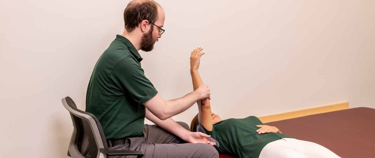 An MSOT student practices a stretch with a patient