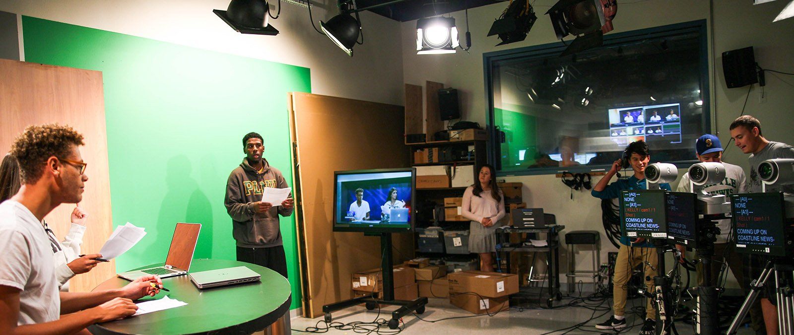 A group of students do a rehearsal for a Point TV broadcast within the production studio.