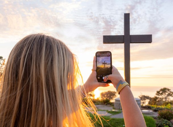 Girl takes photo of the PLNU cross on campus