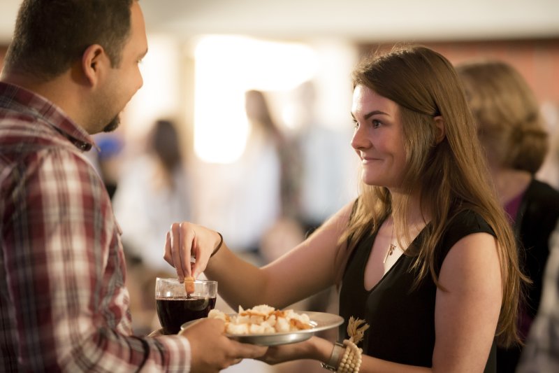 A female Christian studies student takes communion at a PLNU chapel. She is wearing a black shirt and has brown hair.