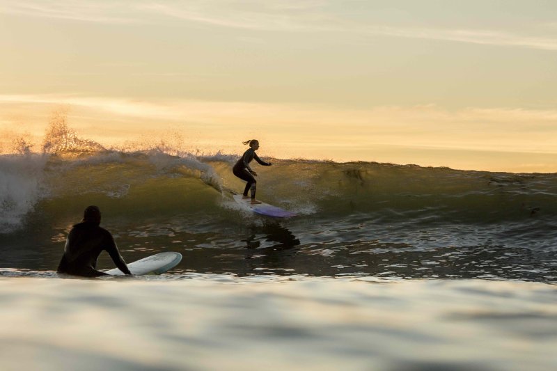 A surfer rides the waves outside PLNU's campus