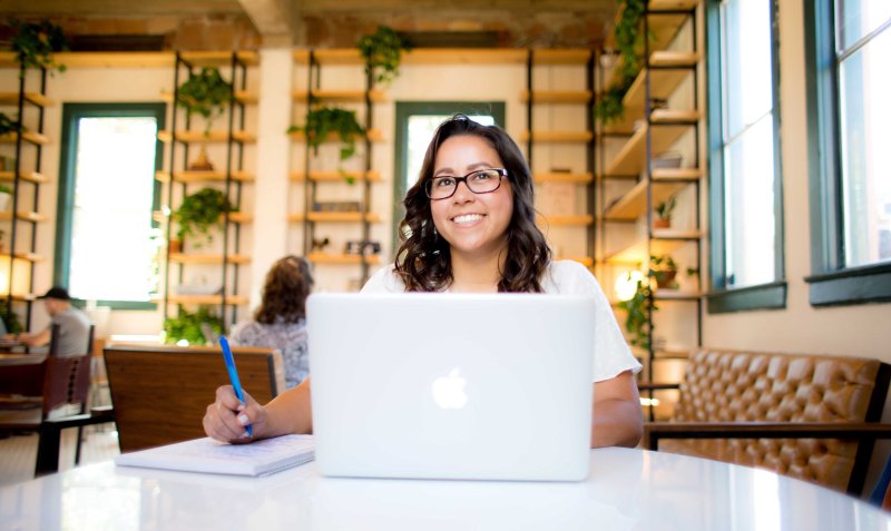 A woman works on her computer at a coffee shop