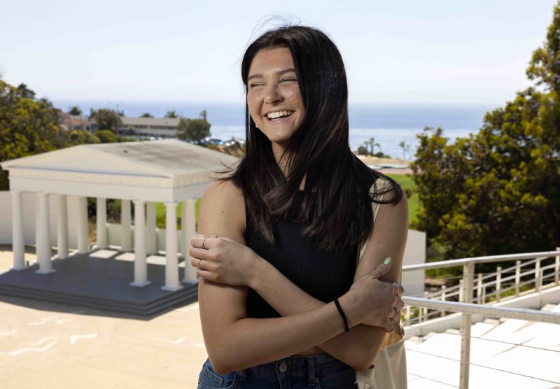 PLNU student smiles near the Greek outside