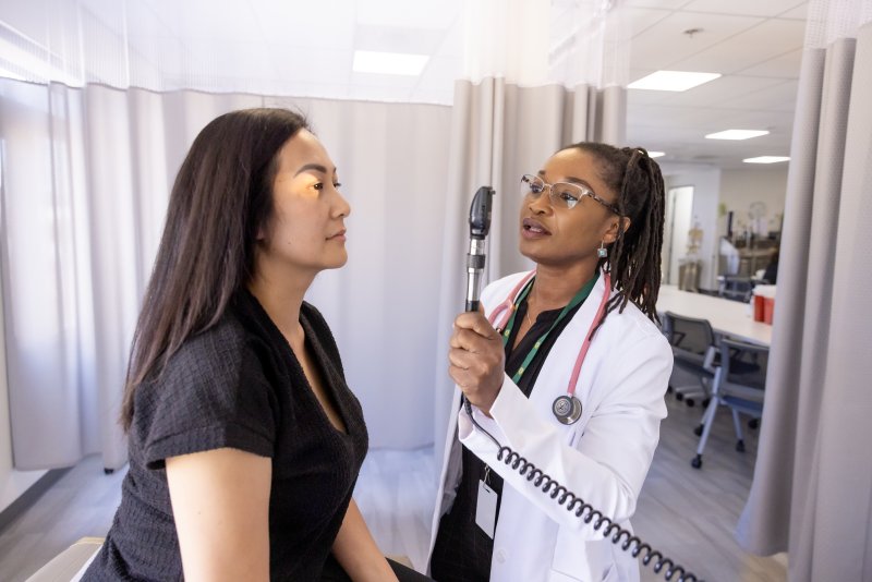 PLNU nurse performs health examination on volunteer at university's nursing lab.