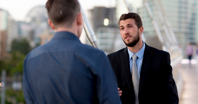 Two businessmen talk outside in San Diego