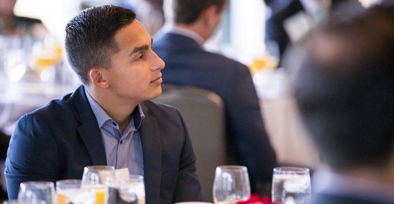 A professionally dressed student attends a business networking event.