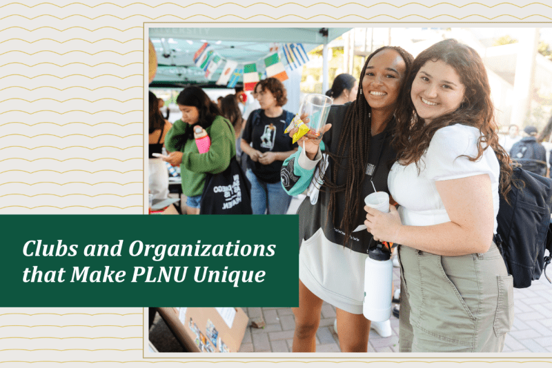 Two students smiling while at the PLNU Club Fair. 