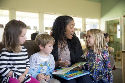 Student reading with children 