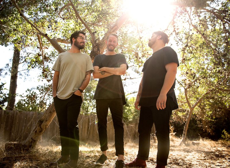 The band Urban Rescue poses for a group photo in a wooded area in the afternoon.