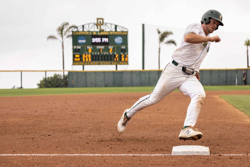 baseball player running over a plate 