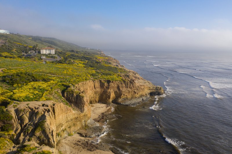 point loma coast with lush green grass and hendricks hall in the distance 