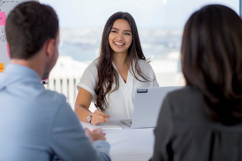 student talking to her peers and smiling 