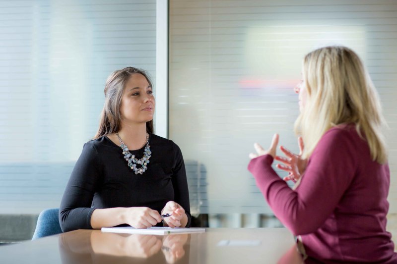 Therapist speaking to a client. both are sitting at a table