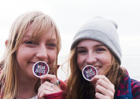 Students holding up CJR Wear Justice stickers